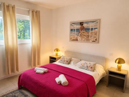 a bedroom with a red bed with two towels on it at Villa Greif Apartment in Lignano Sabbiadoro