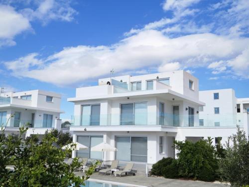 a white building with a pool in front of it at Royal Sugar in Ayia Napa