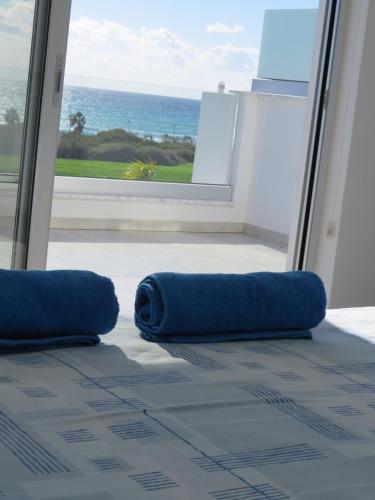 a room with two blue pillows in front of a window at Royal Sugar in Ayia Napa