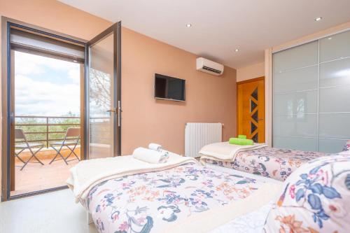 two beds in a room with a balcony at Son Vigili in Campos