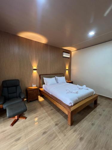 a bedroom with a bed and a chair and a whiteboard at Toba Village Inn in Tuktuk Siadong