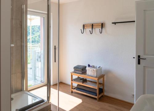 a bathroom with a glass shower and a table at Ferienwohnungen Moselpanorama und Moselblick in Bullay