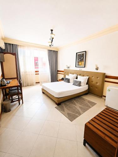a bedroom with a bed and a desk in a room at Hôtel Shalimar in Antananarivo