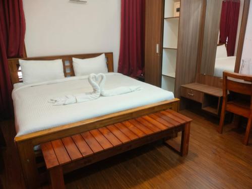a bedroom with a bed with a swan decoration on it at Villa Bella in Ooty