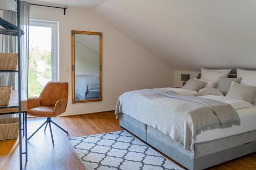 a bedroom with a bed and a mirror and a chair at Ferienwohnungen Moselpanorama und Moselblick in Bullay