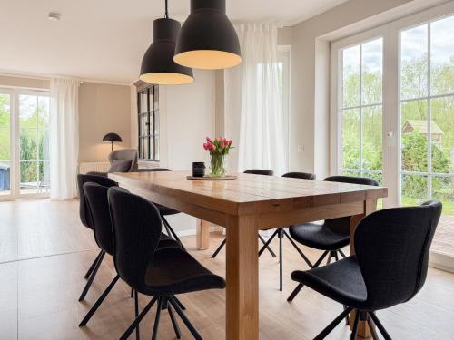 a dining room with a wooden table and black chairs at Seebär in Scharbeutz