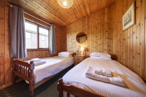 a bedroom with two beds in a wooden cabin at L4 - Porthbeor in Truro
