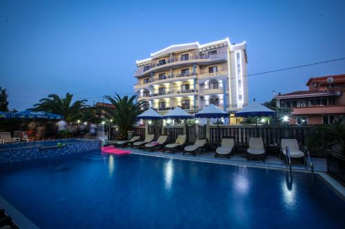 a swimming pool with chairs and a building in the background at Spa Hotel Montefila in Ulcinj