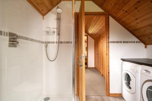 a bathroom with a shower and a washing machine at E40 - Kiberick in Truro
