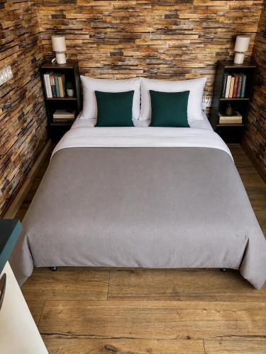 a large bed in a room with a brick wall at Logement avec clim - thé, café et choco dispo in Oye-Plage