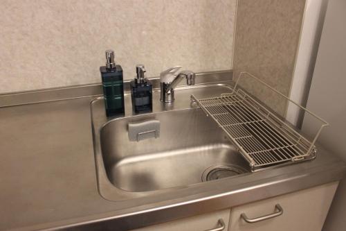 a stainless steel sink with two bottles and a drying rack at 2026APR NEW Open! SETOUCHI BLUE BASE in Utazu
