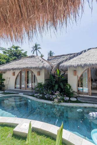 a house with a swimming pool in front of it at Villa Nyantara - Private tropical villa in Gili Islands