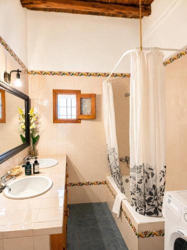 a bathroom with a tub and a sink and a shower at Can Pep Pardal in Sant Miquel de Balansat