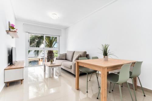 a living room with a table and a couch at Aparthotel Laguna Rosa in Los Montesinos
