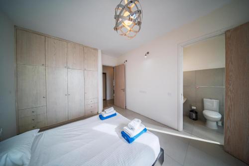 a bedroom with a large bed and a bathroom at Villa Pantheon with Private Pool & Jacuzzi in Pomos