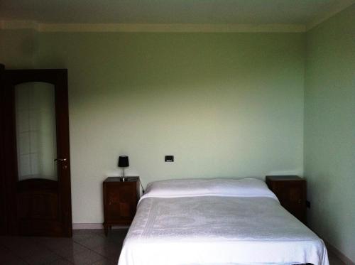 sypialnia z łóżkiem i zieloną ścianą w obiekcie Residenza Nonna Lucia w mieście Roccaforte Mondovì