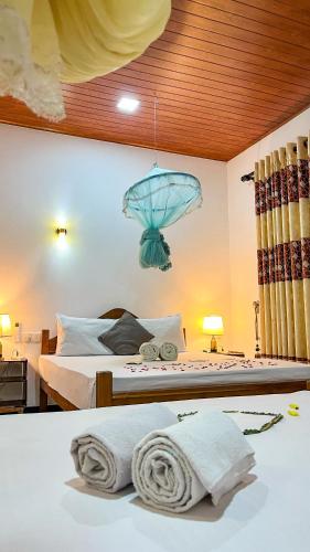 a bedroom with two beds and a chandelier at Horizon Resort & Hostel Sigiriya in Sigiriya