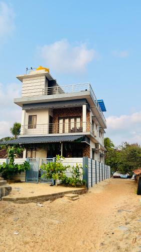 a house on the beach with a fence in front of it at Eevara Beach By Shore in Kaup