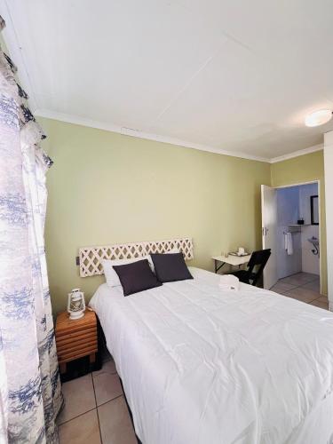 a bedroom with a large white bed in a room at Clock Inn Self Catering Accommodation in Gaborone