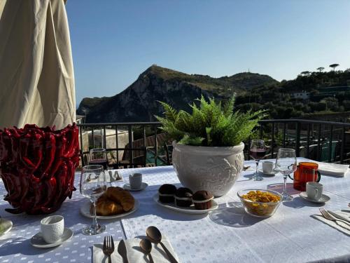 a table with plates of food and a vase at Torre Saracena Massa Lubrense in Massa Lubrense