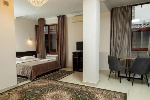 a bedroom with a bed and a desk and a table at Таугуль in Zhezdi