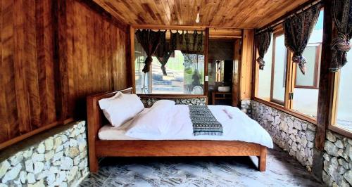 a bedroom with a bed in a stone wall at Luna Valley Homestay in Sapa