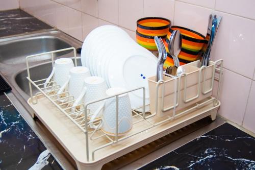 a dish rack with plates and utensils in a kitchen at Guesthouse Chez Marco in Cotonou