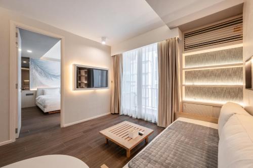 a living room with a couch and a tv at Bayphere Residence Private Beach With Fitness and Pool in Na Jomtien
