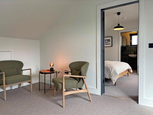 a room with two chairs and a table and a bed at Cottage 505 - Roundstone in Roundstone