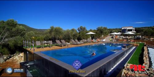 a pool at a resort with people swimming in it at Villa Del Mar in Vasiliki