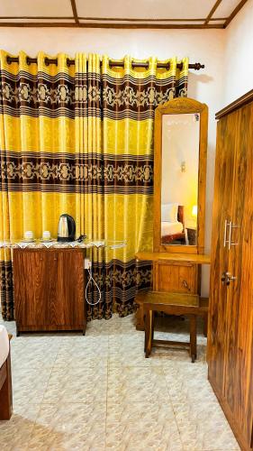 a bathroom with a yellow curtain and a mirror at Horizon Resort & Hostel Sigiriya in Sigiriya