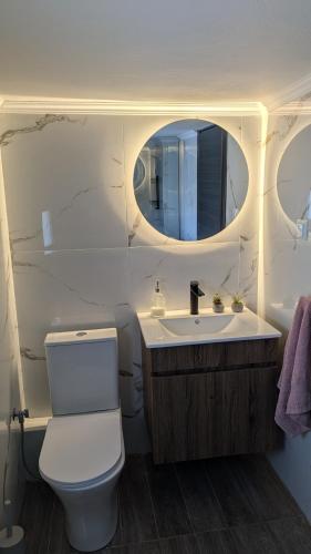 a bathroom with a toilet and a sink with a mirror at City Flights in Kavála