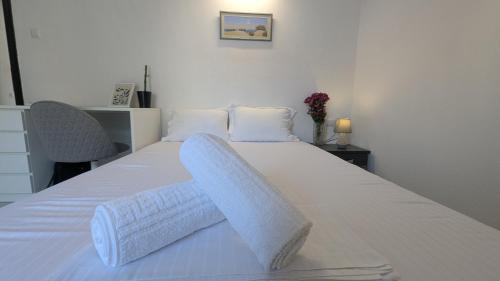 a bedroom with a white bed with white sheets at City Flights in Kavála