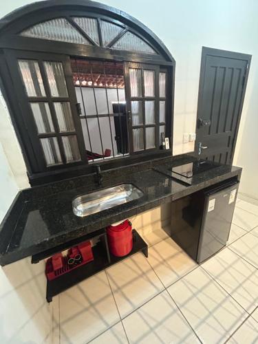 a bathroom with a sink and a mirror at Studio Industrial Moderno in Serra