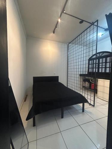 a bedroom with a black bed in a room at Studio Industrial Moderno in Serra