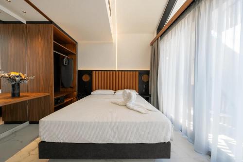 a bedroom with a bed with white sheets and a television at The Orbital in Fanari