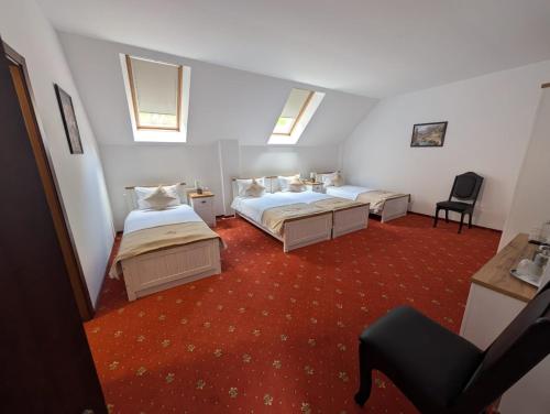 a hotel room with two beds and a chair at Albert Mountain Retreat & SPA in Lepşa