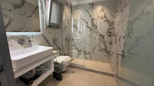 a bathroom with a sink and a toilet and a shower at Lovely Hot-L in Fira