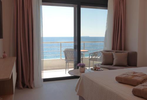 a bedroom with a bed and a view of the ocean at Anel Rooms in Himare