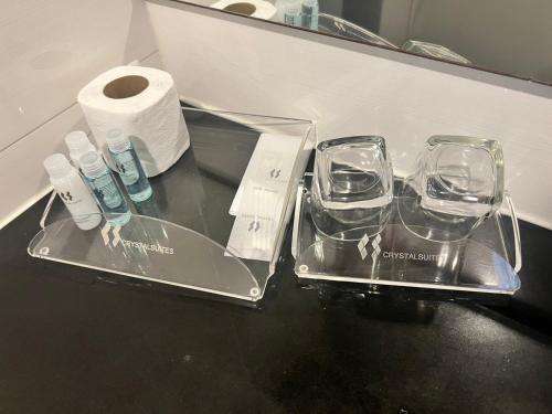 Eine Theke mit zwei leeren Gläsern und einer Rolle Toilettenpapier in der Unterkunft Crystal Suites Suvarnbhumi Airport in Lat Krabang