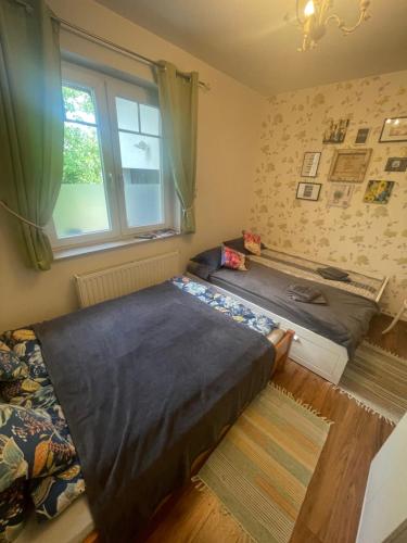 a bedroom with two beds and a window at Rozmaring Vendégház in Orosháza