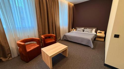 a bedroom with a bed and a chair and a table at Готель Гоголь in Poltava