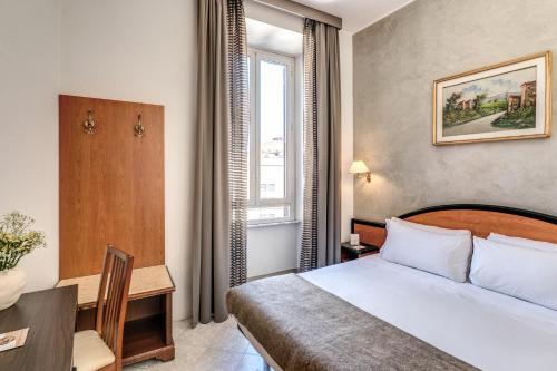 un dormitorio con una cama, un escritorio y una ventana en Hotel Sonya, en Roma