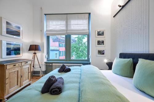a bedroom with a bed with towels on it at seeglueck Altstadt Urban in Konstanz