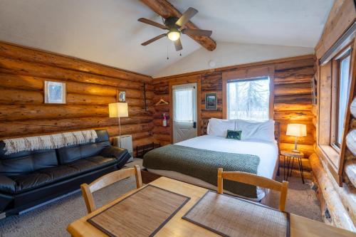a bedroom with a bed and a couch in a room at Hatcher Pass Cabins in Palmer