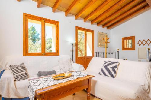a living room with a white couch and a table at Es Coll d'en Pastor in Fornalutx