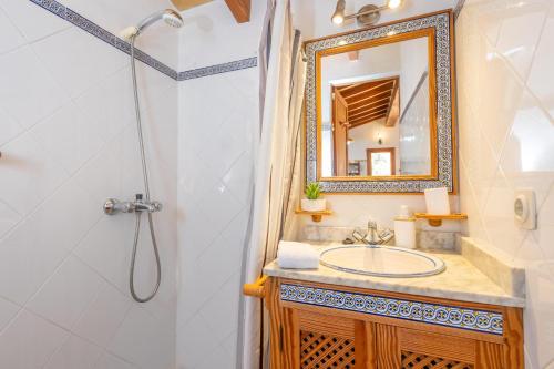 a bathroom with a sink and a shower and a mirror at Es Coll d'en Pastor in Fornalutx