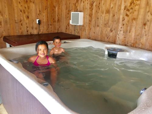 two children sitting in a bath tub at Stratford Motel & Holiday Park in Stratford