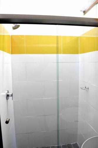 a bathroom with a shower with yellow and white stripes at Cabañas el Chalet in Morelia