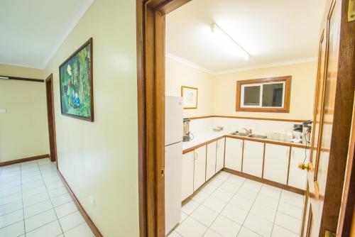 a kitchen with a refrigerator and a sink at Madang Resort in Madang